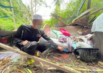 MUHAMMAD Fitri Rosli (kiri) menunjukkan katil ibunya yang bengkok akibat dihempap pokok kelapa yang meragut nyawa warga emas itu di rumah mereka di Jalan Bukit Kecil, Kampung Behor Temak, Kangar, Perlis semalam.- UTUSAN /NUR NAZLINA NADZARI