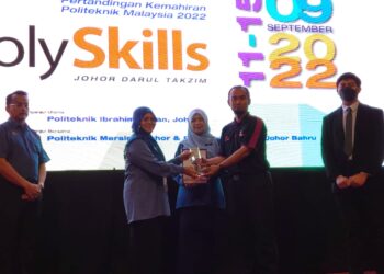 NORHAYATI ZAKARIA (dua dari kiri) menyampaikan anugerah kepada seorang pemenang  Polyskills 2022 di Politeknik Ibrahim Sultan, Pasir Gudang, hari ini.