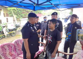 KAMARUL ZAMAN MAMAT (kiri) menenangkan Muhammad Fikri Abdul Mubian, bapa kepada dua beradik yang maut dalam kebakaran di Kampung Dato' Sulaiman Menteri, Johor Bahru.