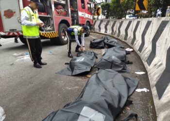ANGGOTA polis memeriksa mayat mangsa yang maut dalam kemalangan jalan raya di Kilometer 4.8, Jalan Genting Highlands di Bentong, Pahang. - FOTO/IHSAN IPD BENTONG