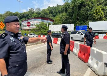 SIK Choon Foo (kiri) bersama pegawai trafik IPD Gua Musang membuat pemantauan lencongan oleh Jabatan Kerja Raya (JKR) di hadapan Ibu Pejabat Polis Daerah (IPD) Gua Musang, Gua Musang, Kelantan semalam. -UTUSAN/AIMUNI TUAN LAH