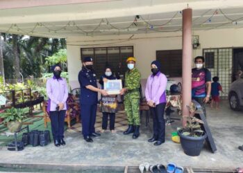 Hazri Mohamad  (dua, kiri) menyampaikan sumbangan kepada Anita sempena Program Op Bantu Peringkat Ibu Pejabat Polis Daerah (IPD) Rembau di kuartes Estet Pelin, di sini, hari ini. – UTUSAN/NOR AINNA HAMZAH