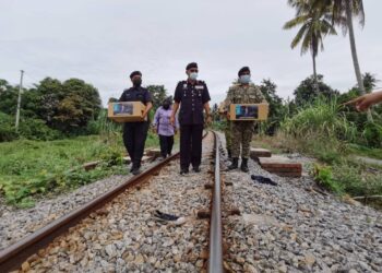 PEGAWAI dan anggota polis IPD Tumpat dibantu tentera mengedarkan barangan makanan kepada penduduk di Kampung Belukar Berangan,  Tumpat hari ini. - UTUSAN/ROSALWANI CHE SOH