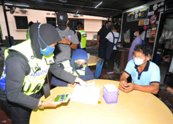 ANGGOTA penguat kuasa JAINJ menahan seorang lelaki yang didapati tidak puasa dengan makan di sebuah warung dalam operasi di Wadi Hana, Johor Bahru di sini. - UTUSAN/RAJA JAAFAR ALI