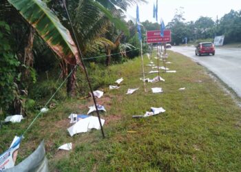 BARISAN poster gambar calon sebuah parti politik terkoyak dan bertebaran di atas tanah akibat hujan lebat dan ribut berdekatan jalan raya di Kampung Jeram Bungor di Lipis, Pahang. - FOTO/HARIS FADILAH AHMAD