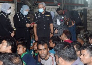 SHAH Inor Shahbudin memeriksa dokumen pengenalan PATI ketika serbuan di sebuah kilang membuat plastik dan kotak di Juru, Pulau Pinang hari ini.