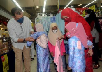 NORLIZA Abdul Rahim dan Noor Azmi Salleh menyantuni anak yatim dan asnaf mencuba pakaian baharu pada Majlis Syukuri Ramadan @ Penang oleh UDA Holdings di Mydin Kepala Batas, Pulau Pinang, semalam. – FOTO/IQBAL HAMDAN