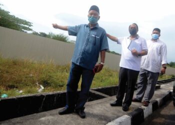 PENDUDUK, Muhammad Idris Saleh (kiri), Muhammad Farid Saad (tengah) dan Sophian Mohd. Zain (kanan) menunjukkan lokasi asrama warga asing yang bakal dibina di Tingkat Teluk Kumbar, Pulau Pinang, semalam. - FOTO/IQBAL HAMDAN