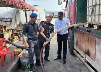 S. JEGAN (kanan) melihat demonstrasi menyalurkan minyak diesel daripada tangki yang diubah suai ke dalam tangki simpanan di Bukit Mertajam, Pulau Pinang hari ini.