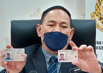 ADENAN Md. Isa menunjukkan perbezaan antara lesen memandu asli (kanan) dan lesen memandu tiruan dalam sidang akhbar di pejabat JPJ Pulau Pinang di Seberang Jaya hari ini.