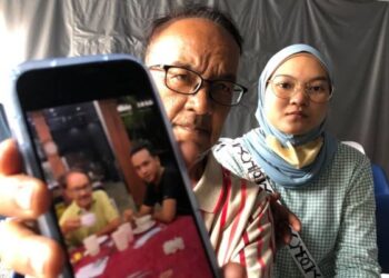 HARRIS Shariff menunjukkan gambar kenangan bersama anaknya, Mohd. Haziq iaitu mangsa kelima yang meninggal dunia dalam kemalangan melibatkan beberapa buah motosikal di Lebuh Raya Tun Dr. Lim Chong Eu, Georgetown, Pulau Pinang awal pagi Ahad lalu.