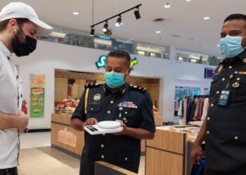 A. MOGAN (tengah) menunjukkan alat timbang tidak memenuhi syarat yang digunakan oleh seorang peniaga di sebuah pasar raya di Seberang Jaya, Pulau Pinang hari ini.