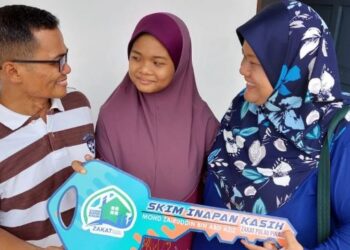 MOHD. ZAIRUDDIN Abd. Aziz bersama isteri, Bahirah Ariffin dan anak tunggal mereka, Nurbatrisyia Balqis selepas menerima kunci rumah di bawah program Skim Inapan Kasih di Kampung Permatang Pak Elong, Penaga, Pulau Pinang semalam.