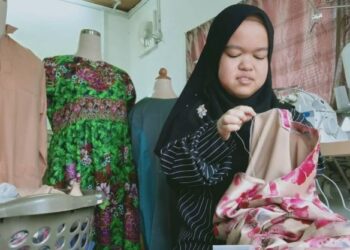 NURUL IZZAH Mohd. Asri sedang menyiapkan tempahan baju kurung pelanggannya sempena Aidilfitri kelak di rumahnya di Sungai Dua, Butterworth, Pulau Pinang. - FOTO/NORUL AKMA MOHD. ZAIN