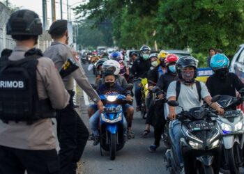 PIHAK polis melakukan pemeriksaan terhadap penunggang motosikal yang melalui jambatan Suramadu dari Surabaya ke Pulau Madura sempena Hari Raya Korban. -AFP