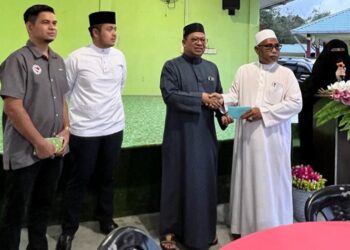 ZUHAIRI Ab. Kadir (tiga dari kiri) menyampaikan sumbangan duit raya pada majlis berbuka puasa bersama anak yatim dan warga emas di Madrasah Kamaliah Kampung Cherok Paloh di Kuantan, Pahang.