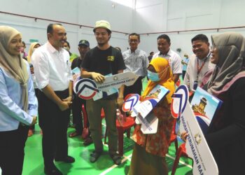 MOHD. Jafni Md. Shukor beramah mesra dengan mangsa ribut selepas Majlis Penyerahan Kunci Sementara PPR Pelangi Indah, Johor Bahru, hari ini.