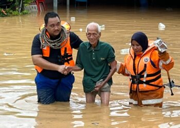 PASUKAN penyelamat membantu memindahkan penghuni Rumah Sejahtera di Bidor ke pusat pemindahan sementara selepas pusat jagaan dihuni mereka dinaiki air banjir. - IHSAN APM PERAK
