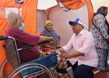 CALON BN Parlimen Sepang, Anuar Basiran berbual dengan mangsa banjir ketika melawat di PPS di Dewan Komuniti Dengkil, Selangor. - UTUSAN/FAISOL MUSTAFA