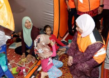 MAZIAH Che Yusoff (kanan) beramah mesra dengan mangsa banjir di salah sebuah PPS di Dengkil, Selangor.