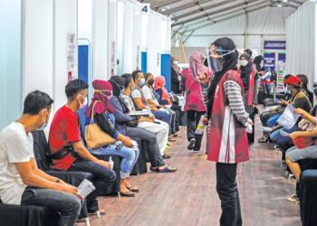 ORANG ramai menunggu giliran menerima vaksin Covid-19 di Pusat Pengambilan Vaksin Bukit Jalil, Kuala Lumpur, semalam. – UTUSAN/SHIDDIEQIIN ZON