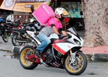 Bekas pramugara, Ishaq Radzim Ismail menunggang motosikal berkuasa tinggi  bekerja sebagai penghantar makanan selepas tidak bekerja kesan dari  pandemik Covid-19 di Pulau Pinang. -MINGGUAN/ NOOR HASLIZA NUSI