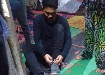 SEORANG remaja bersiap untuk mengambil ujian kemasukan universiti dan terpaksa meninggalkan jenazah bapanya di Sumatera Utara, Indonesia. - AGENSI