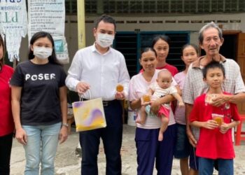 CHONG Zhemin (tiga dari kiri) menyampaikan bantuan kuih bulan kepada keluarga mualaf miskin yang menetap di Malim Nawar.