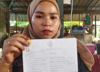 NOOR AFIFAH Mohd. Rahim menunjukkan borang untuk majlis pernikahannya ketika ditemui di Kampung Kuala Gula, Bagan Serai, Perak, hari ini. - FOTO/WAT KAMAL ABAS