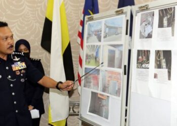 MOHD. Yusri Hassan Basri (kanan) menunjukkan gambar premis perniagaan makanan sejuk beku di Hutan Melintang yang diserbu semalam kerana didapati melakukan pengubahsuaian meter TNB bagi tujuan mencuri elektrik dalam sidang akhbar di IPKPerak di Ipoh hari ini.