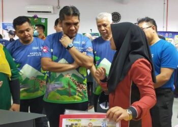 RADZI Jidin (tengah) diberi penerangan oleh Nurul Alia Maisarah Mohd. Helmi mengenai jus nanas dan kerepek nanas pada Program Eksplorasi Alam Lestari Siri Ketiga di Pusat Konservasi Hidupan Liar (PKHL) di Sungkai, Tanjung Malim hari ini. - FOTO/ASLIZA MUSA