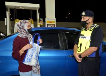 MIOR Faridalathrash Wahid (kanan) beramah mesra bersama pengguna jalan raya pada program GTSP dan Pemantauan Lalu Lintas di Stesen Minyak Shell RTC Simpang Pulai arah utara, Ipoh hari ini. - FOTO/ZULFACHRI ZULKIFLI
