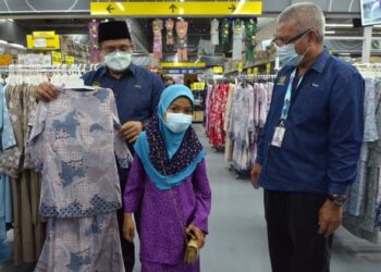 MOHD. Akmal Kamarudin (kiri) memilihkan baju raya untuk kanak-kanak pada program santuni asnaf di Gopeng, Perak, hari ini. - FOTO/ZULFACHRI ZULKIFLI