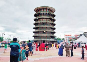 ORANG ramai merakam gambar berhari raya di Dataran Menara Condong Teluk Intan, Perak. - UTUSAN/AIN SAFRE BIDIN