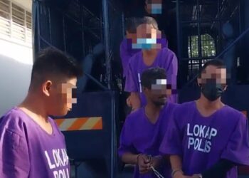 SUSPEK kes rogol yang berlaku 19 tahun lalu (belakang, tengah) dibawa turun dari trak polis untuk prosiding reman di Mahkamah Majistret Parit Buntar hari ini. - UTUSAN/WAT KAMAL ABAS