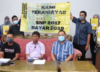 ASMUNI Awi (depan, tengah) bersama pembeli rumah pangsapuri  D Aman Residensi Meru Raya dalam sidang akhbar di Ipoh, Perak, hari ini. - FOTO/MUHAMAD NAZREEN SYAH MUSTHAFA
