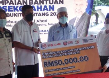 IDRIS Ahmad (dua dari kanan) menyampaikan cek bantuan persekolahan pelajar asnaf di Taiping hari ini. - FOTO/WAT KAMAL ABAS