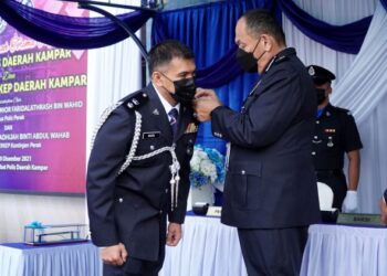 MIOR Faridalathrash Wahid (kanan) memakaikan pangkat kepada Mohamad Nazri Daud pada Majlis Serah Terima Tugas Jawatan Ketua Polis Daerah Kampar di IPD Kampar, Perak, hari ini. - FOTO/ZULFACHRI ZULKIFLI