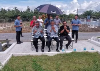 AHMAD Zahid Hamidi (depan, tengah) berdoa ketika menziarahi kubur ibu dan bapanya di Sungai Nipah Darat, Bagan Datuk hari ini. - FOTO/AIN SAFRE BIDIN