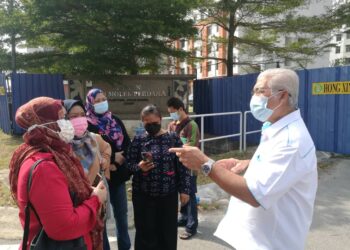 HASSAN Abdul Karim (kanan) mendengar keluhan pembeli yang berdepan masalah rumah terbengkalai di Taman Seri Molek Perdana, Plentong, Johor. - UTUSAN/MOHAMAD FAIZAL HASHIM