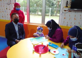 HASNI Mohammad (duduk, kiri) melihat seorang murid mengikuti sesi pembelajaran di Jauhar Child Care, di Kota Iskandar, Iskandar Puteri di Johor.