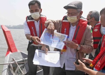 TIMBALAN Ketua Menteri I, Datuk Ahmad Zakiyuddin Abdul Rahman (tengah) menunjukkan pelan tambakan laut ketika meninjau tapak projek PSR di Bayan Lepas, Pulau Pinang pada April lalu. – UTUSAN/MOHAMMAD FIRDAUS AMRAN