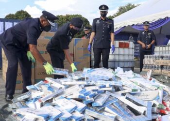 WAN Kamarul Azran Wan Yusof (dua dari kiri) bersama Ketua Jabatan Siasatan Jenayah (JSJ) Selangor, Asisten Komisioner Baharudin Mat Taib (kanan) melupuskan arak yang dirampas ketika pelupusan barang kes Jabatan Siasatan Jenayah (JSJ) di IPD Sepang, Selangor. - FOTO/FAISOL MUSTAFA