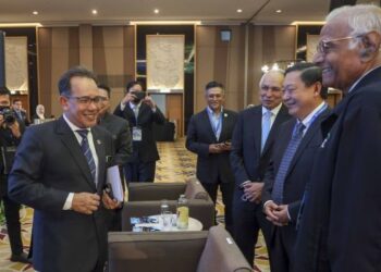 ROSLI Isa (kiri) beramah mesra bersama hadirin selepas merasmikan 10th Simpomin 2022: NR Radioactive Rare Earth Element di Putrajaya. - FOTO/FAISOL MUSTAFA