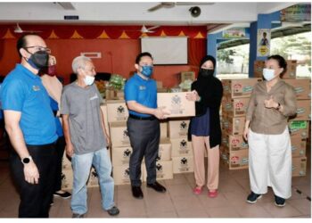 WAN Saiful Wan Jan menyerahkan kit bantuan banjir kepada salah seorang mangsa banjir di pusat pemindahan sementara (PPS) di Jalan Klang Lama.