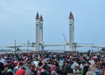 UMAT Islam berbuka puasa berlatar belakang pemandangan Jambatan Angkat Kuala Terengganu di Dataran Taman Shahbandar pada 2019.