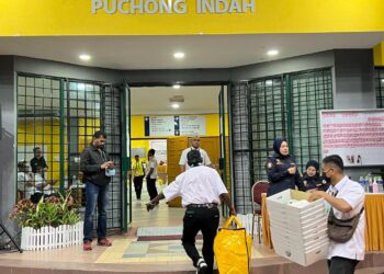 PETUGAS SPR mengangkat peti undi yang baru tiba dari pusat mengundi di Pusat Penjumlahan Rasmi Undi PRU15 P103 Puchong di Dewan Serbaguna MBSJ Puchong Indah, Selangor. - UTUSAN/KAMARIAH KHALIDI