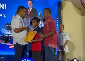 SAIFUDDIN Nasution Ismail (dua dari kiri) menyerahkan kad pengenalan kepada penerima pada Program KDN Madani di Kompleks Perpaduan Jajahan Machang, Kelantan hari ini. UTUSAN/ROSMIZAN RESDI