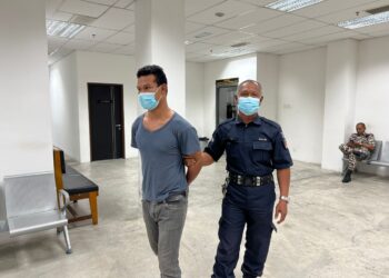 ANGGOTA polis mengiringi Mohd. Asrol Kamal Mohd. Asri semasa menghadiri perbicaraan di Mahkamah Majistret Kota Bharu, Kelantan hari ini.