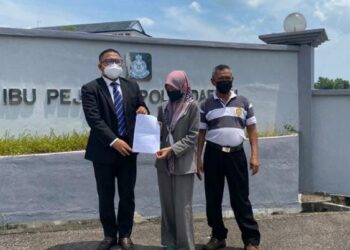 MOHAMAD Asraf Ahmad Sohaimi (kiri) bersama Nurhawatif Ayub menunjukkan laporan polis kematian Zahari Ayub di hadapan IPD Kuala Muda, Sungai Petani hari ini. - UTUSAN/OTHMAN YAHAYA